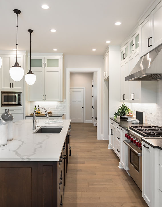 Beautiful white kitchen interior with marble countertops and pendant lights